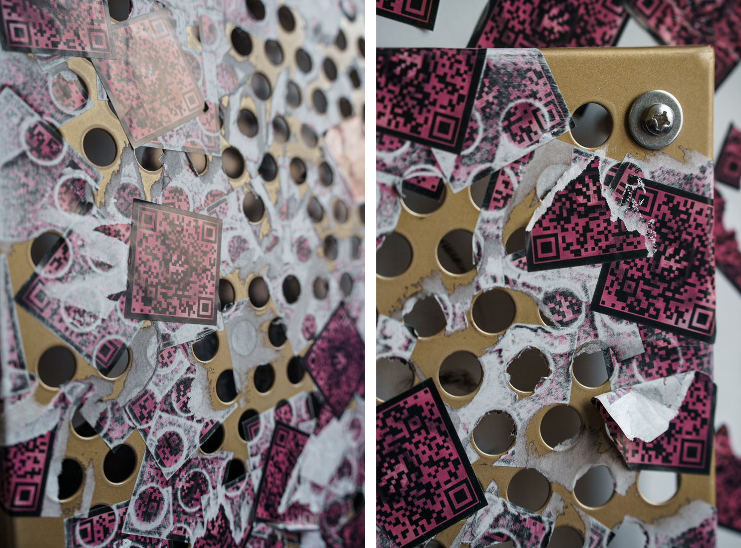 Close-up detail of the perforated gold panel with torn pink QR code stickers layered over the drilled holes